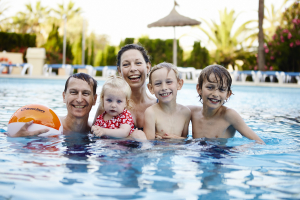 Familie med tre børn i pool på Mallorca